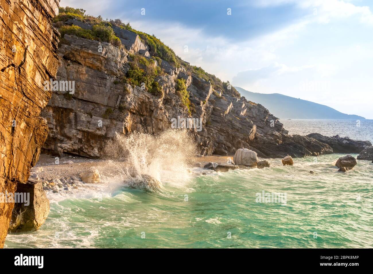 Summer evening and surf spray. Small beach on a rocky seashore Stock Photo