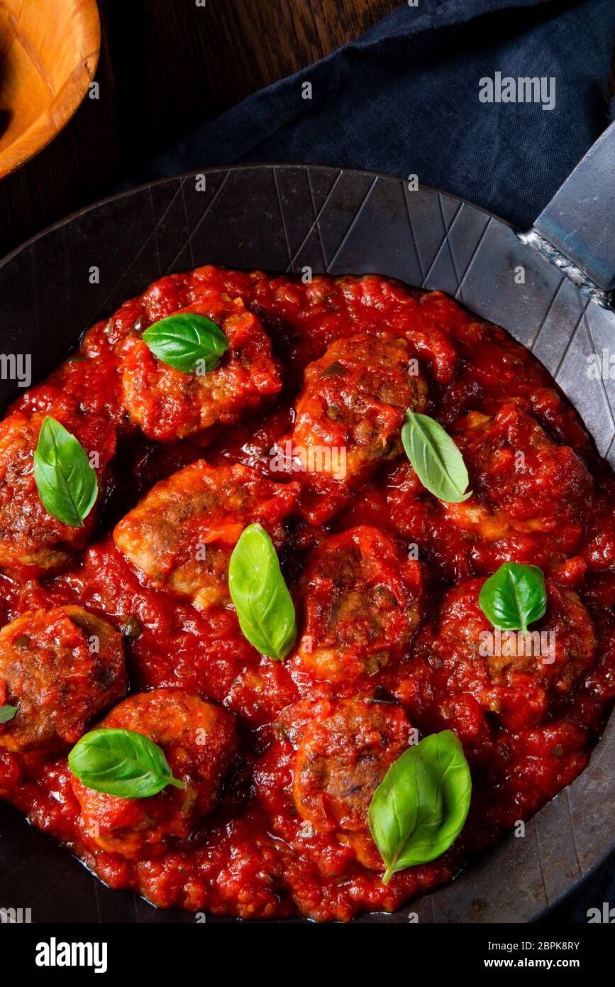 Baked mini meatballs in tomato sauce with basil Stock Photo Alamy