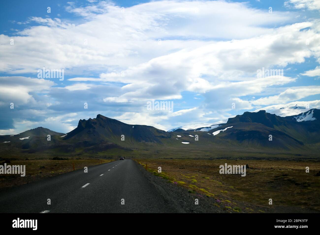 On a roadtrip in Iceland, you can see beautiful sceneries, mountains, snow, blue sky and amazing clouds. Stock Photo