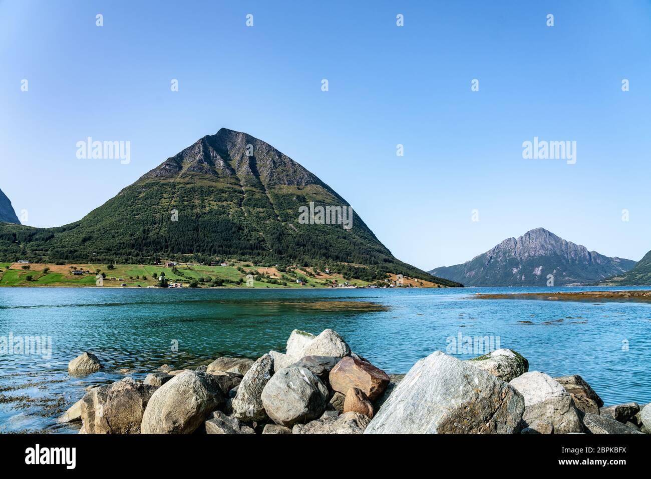 Panoramic view from Luroy at ford with Aldra Island (left), Olvika (center) and some unknown high mountain (left). The wall of heavy stones on sandy b Stock Photo
