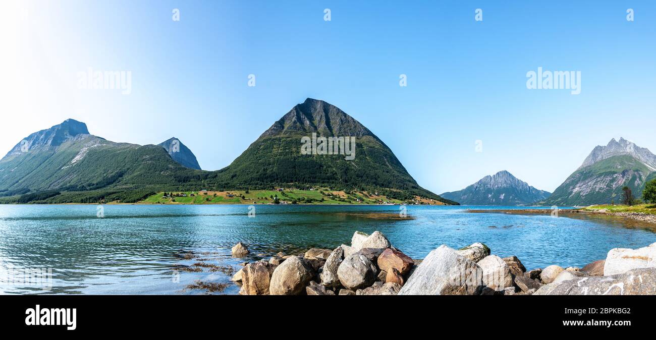 Panoramic view from Luroy at ford with Aldra Island (left), Olvika (center) and some unknown high mountain (left). The wall of heavy stones on sandy b Stock Photo