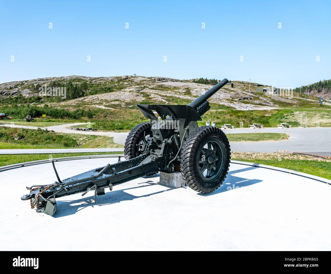 Gronsvik, Norway - August 06, 2019: Back right view at artilery gun standing in front of Main building of museum of Gronsvik coastal battery, Helgelan Stock Photo