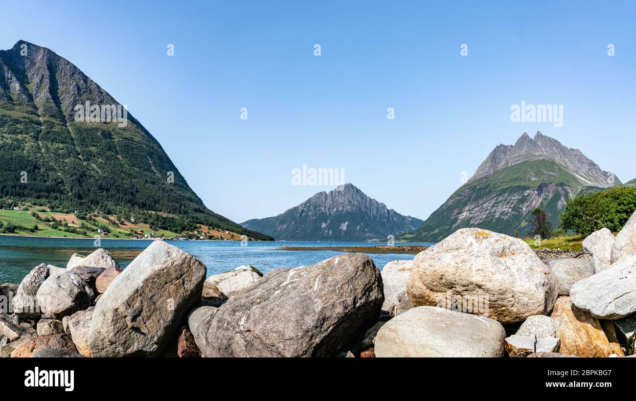 Panoramic view from Luroy at ford with Aldra Island (left), Olvika (center) and some unknown high mountain (left). The wall of heavy stones on sandy b Stock Photo