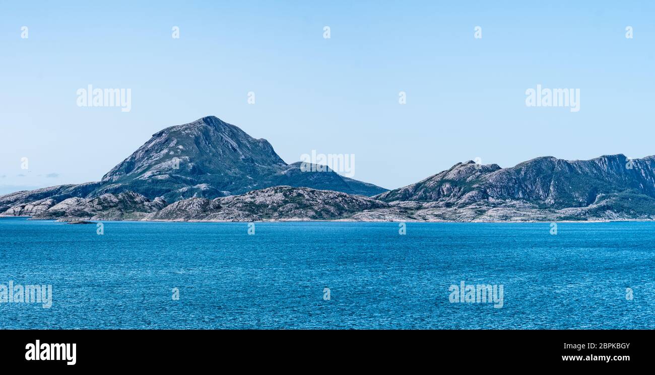 Panoramic view from ferry at beautiful ocean coast close to Nesna town - Mountains, stones, no forest, trip to Nesna, sunny calm summer day, Northern Stock Photo