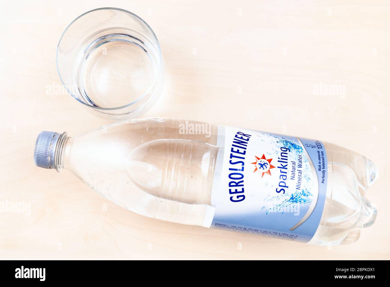 MOSCOW, RUSSIA - MAY 10, 2020: lying plastic bottle of Gerolsteiner Sprudel sparkling water and glass on board. Gerolsteiner is German naturally carbo Stock Photo
