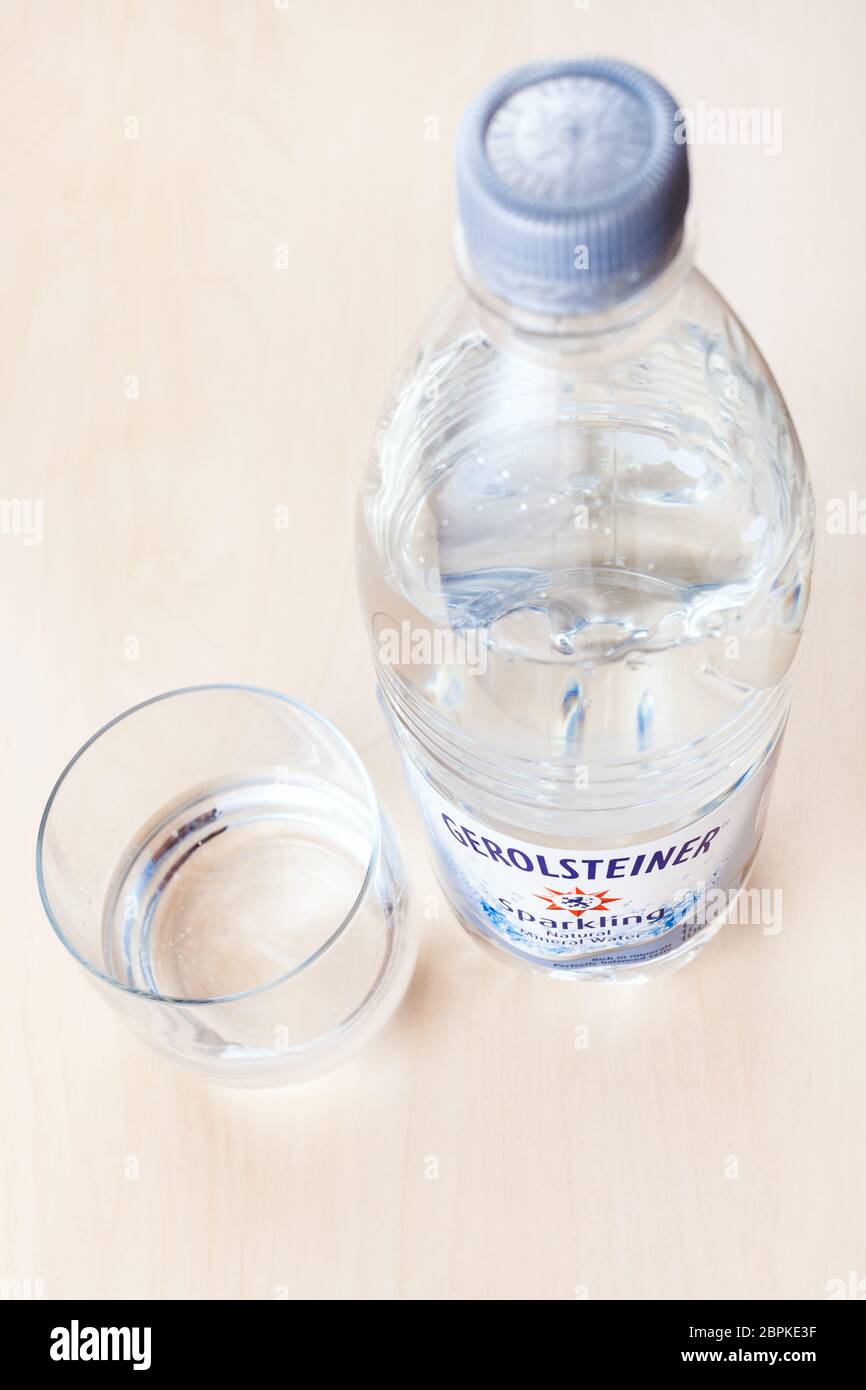MOSCOW, RUSSIA - MAY 10, 2020: plastic bottle of Gerolsteiner Sprudel sparkling water and glass on board. Gerolsteiner is German naturally carbonated Stock Photo