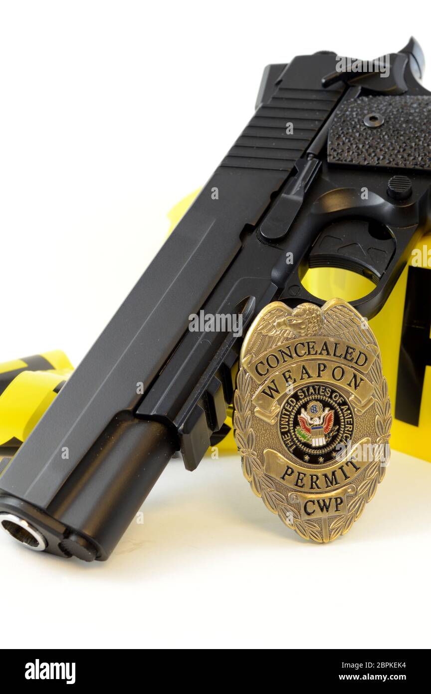 Closeup view of a handgun with a weapons badge and some police tape for