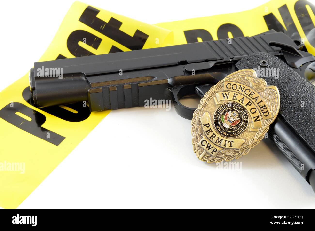 Closeup view of a handgun with a weapons badge and some police tape for