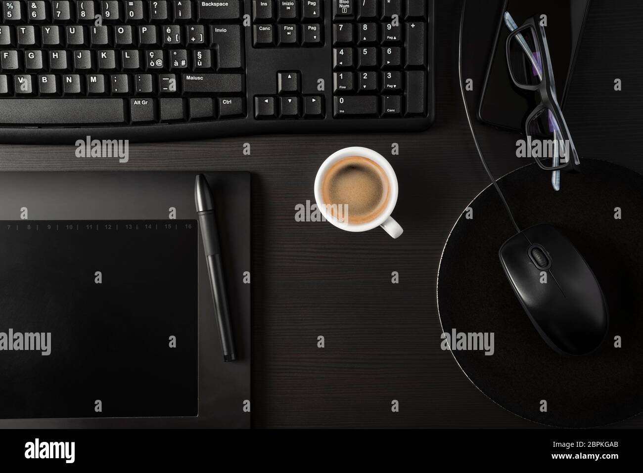 Total black desk with pc, tablet, personal items and cup of coffee Stock Photo