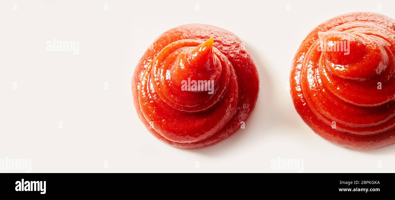 Two swirls of fresh homemade tomato sauce, catsup or ketchup isolated