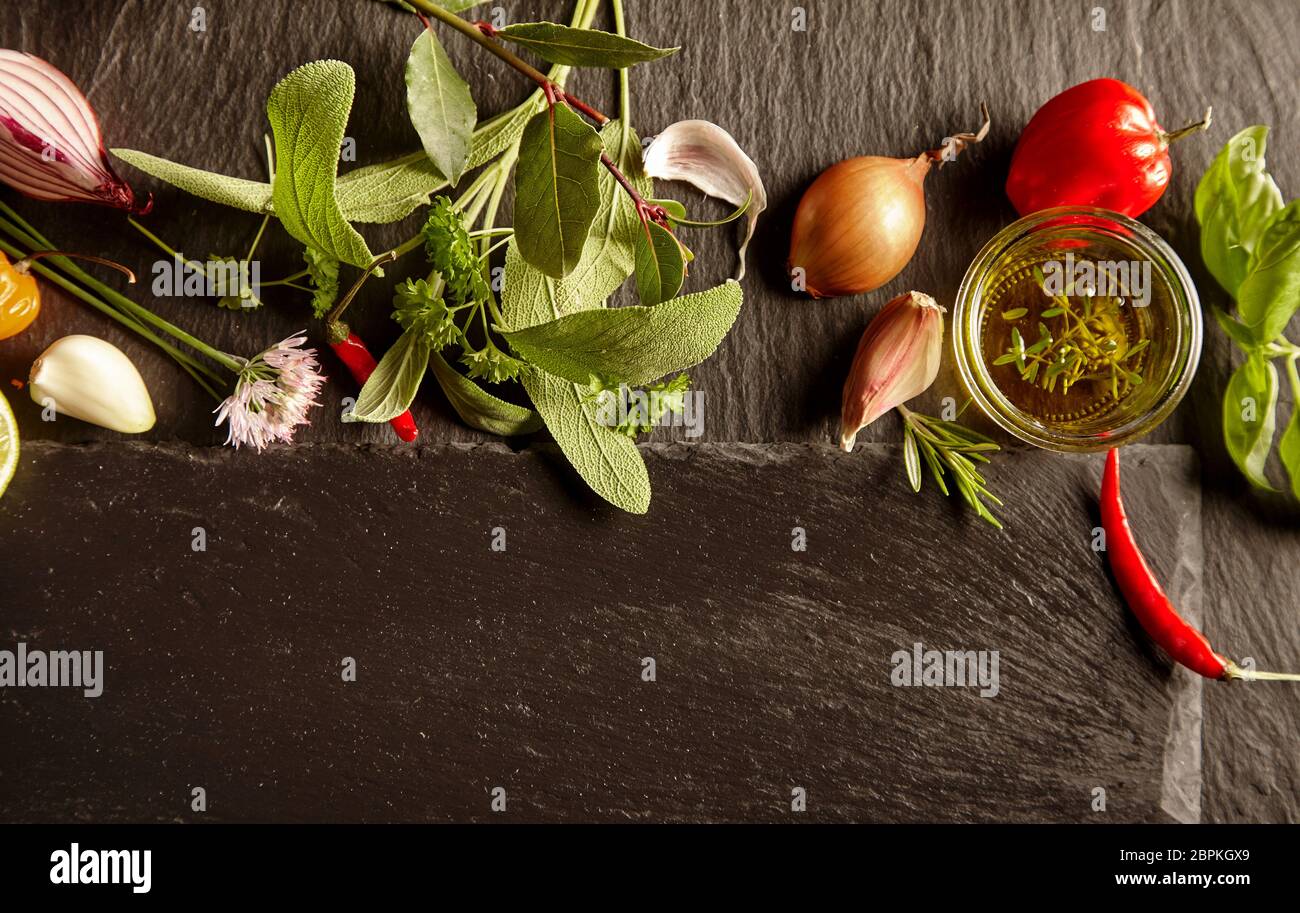 Set of spices and herbs in kitchen layout, viewed from above on dark ...