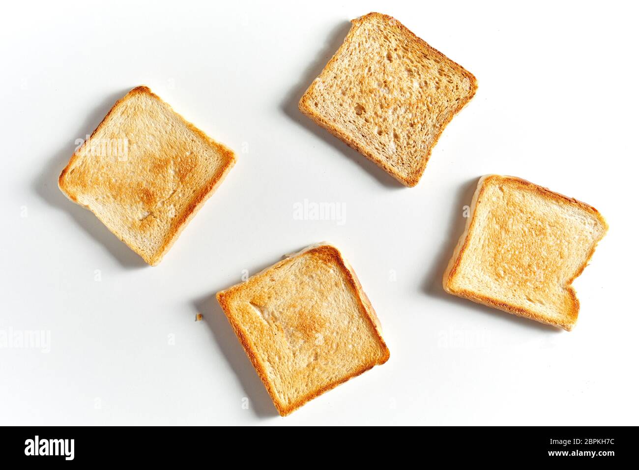 Set of four fried toast bread slices isolated on white background with shadow, viewed from above Stock Photo