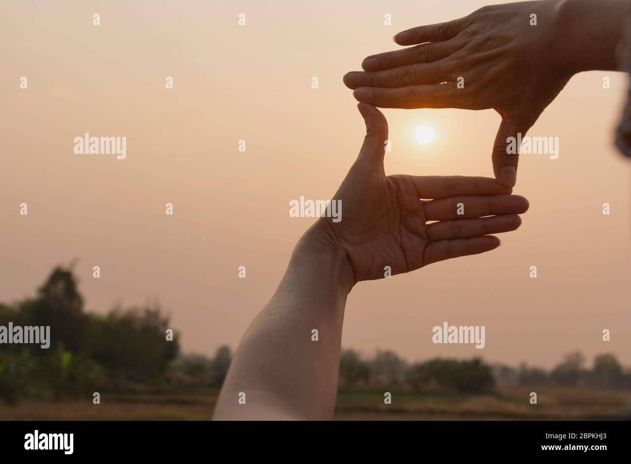 Hands making frame with sunset. Close up of woman hands making frame ...