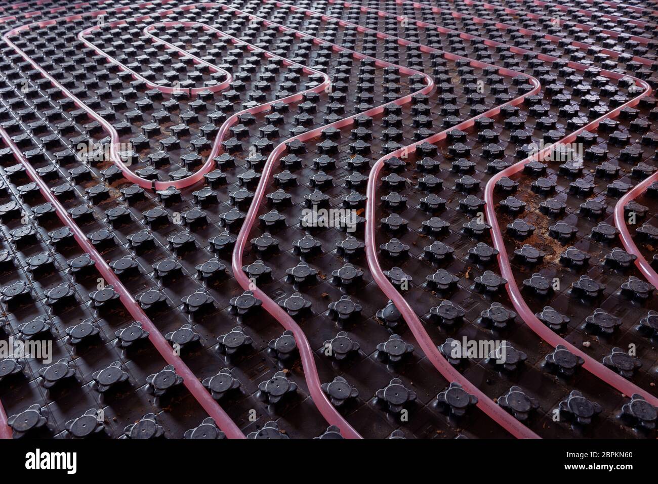 Underfloor heating system installation. Close up on water floor heating system interior of a new residential building. Pipes filled with propylene Stock Photo