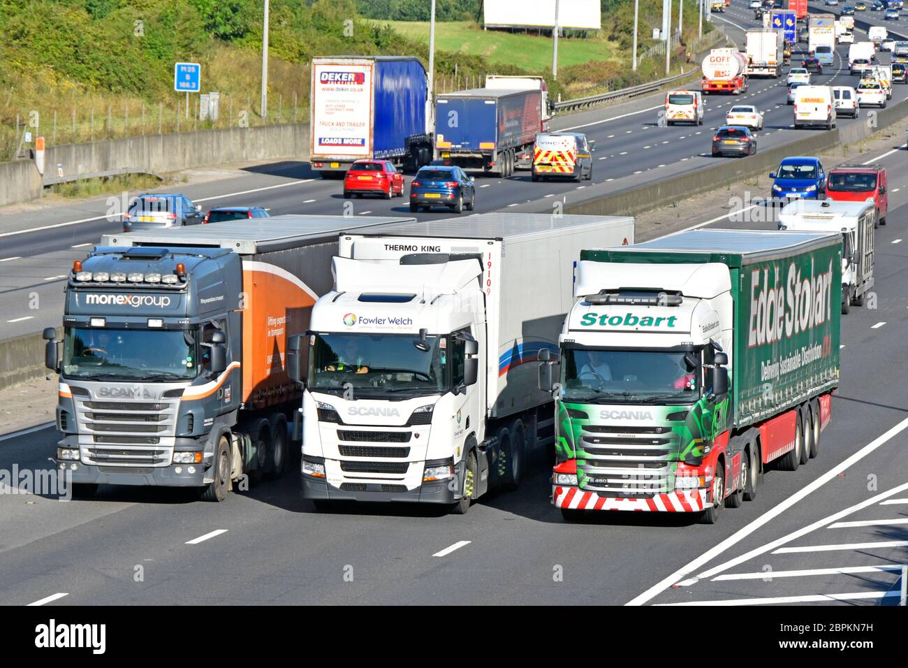 Drivers in cabs of supply chain haulage hgv lorry truck articulated trailer overtaking in traffic lorries trucks busy four lane motorway England UK Stock Photo