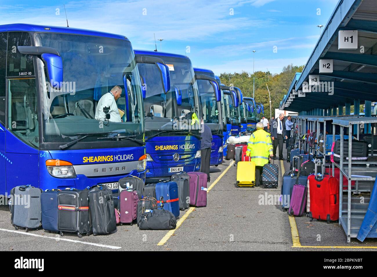 Outdoor luggage logistics hub for sorting & loading passengers holiday tour suitcases onto Shearings coaches Scratchwood Services London England UK Stock Photo