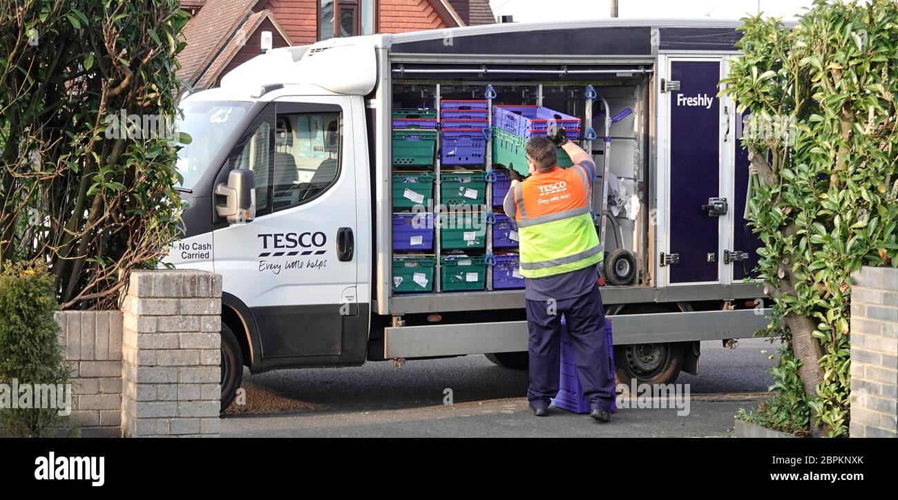 Tesco supermarket online grocery home shopping van driver sorting crates  onto trolley for customer food order for unloading delivery at front door  UK Stock Photo - Alamy