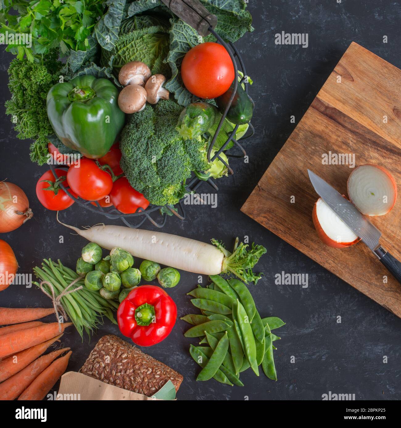 Healthy vegetable selection with rustic cutting board on a slate plate Stock Photo