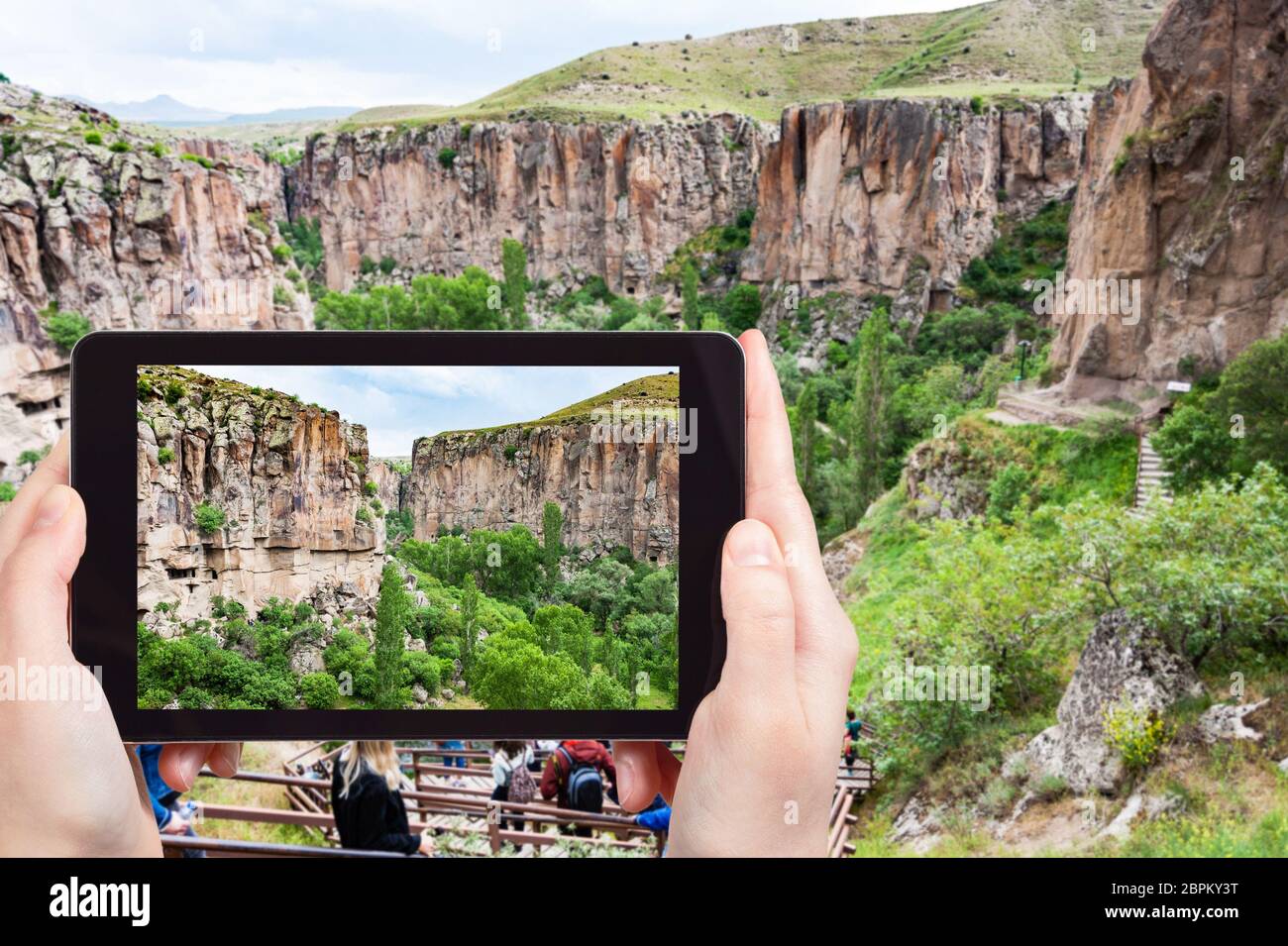 travel concept - tourist photographs of natural gorge of Ihlara river Valley in Aksaray Province in Cappadocia on smartphone in Turkey in spring Stock Photo