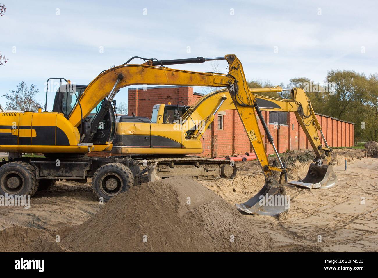 two yellow excavators parked at construction site Stock Photo - Alamy