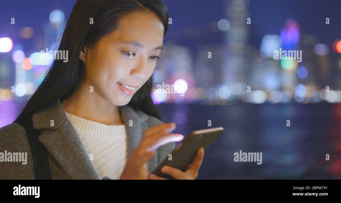 Business woman using cellphone in Hong Kong city at night Stock Photo ...