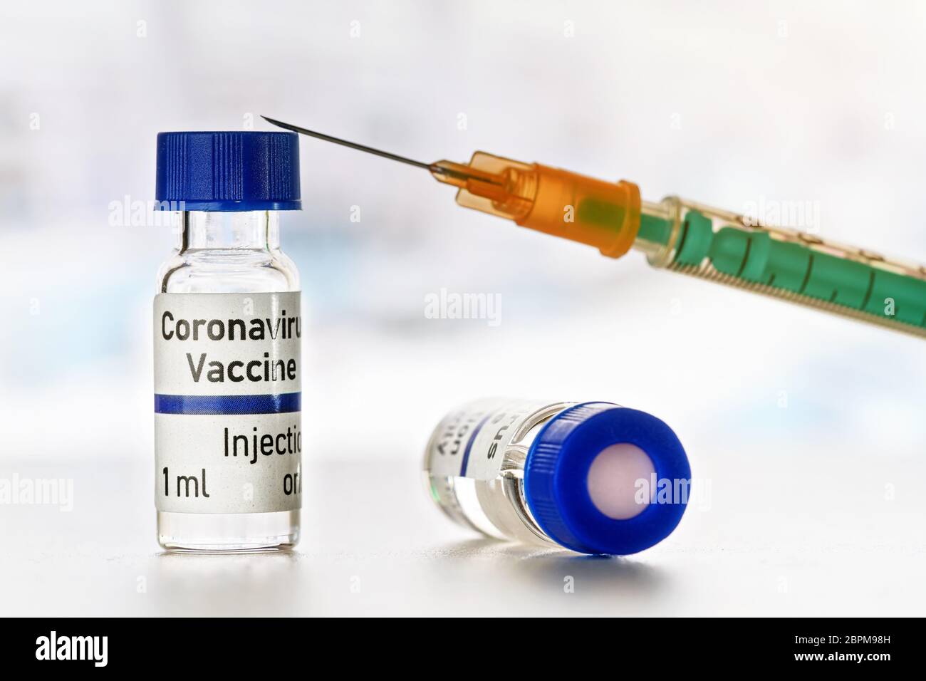 Coronavirus covid-19 vaccine concept - two small bottles with blue caps ...