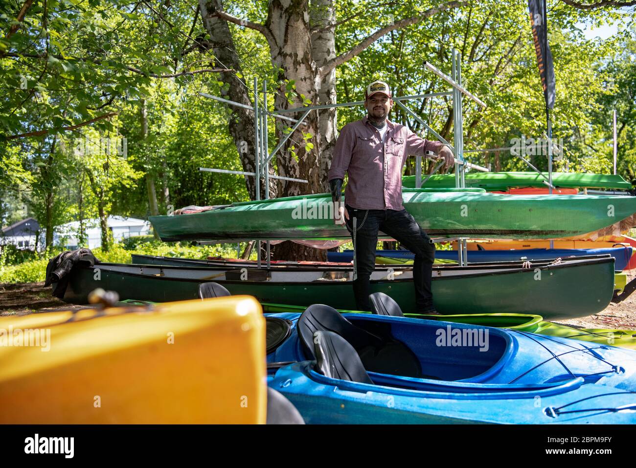 Hennigsdorf, Germany. 06th May, 2020. Patrick Dittmer from Kajakguru in  Hennigsdorf is standing between the rental boats. After the Corona  measures, he now hopes that many people will go on a boat
