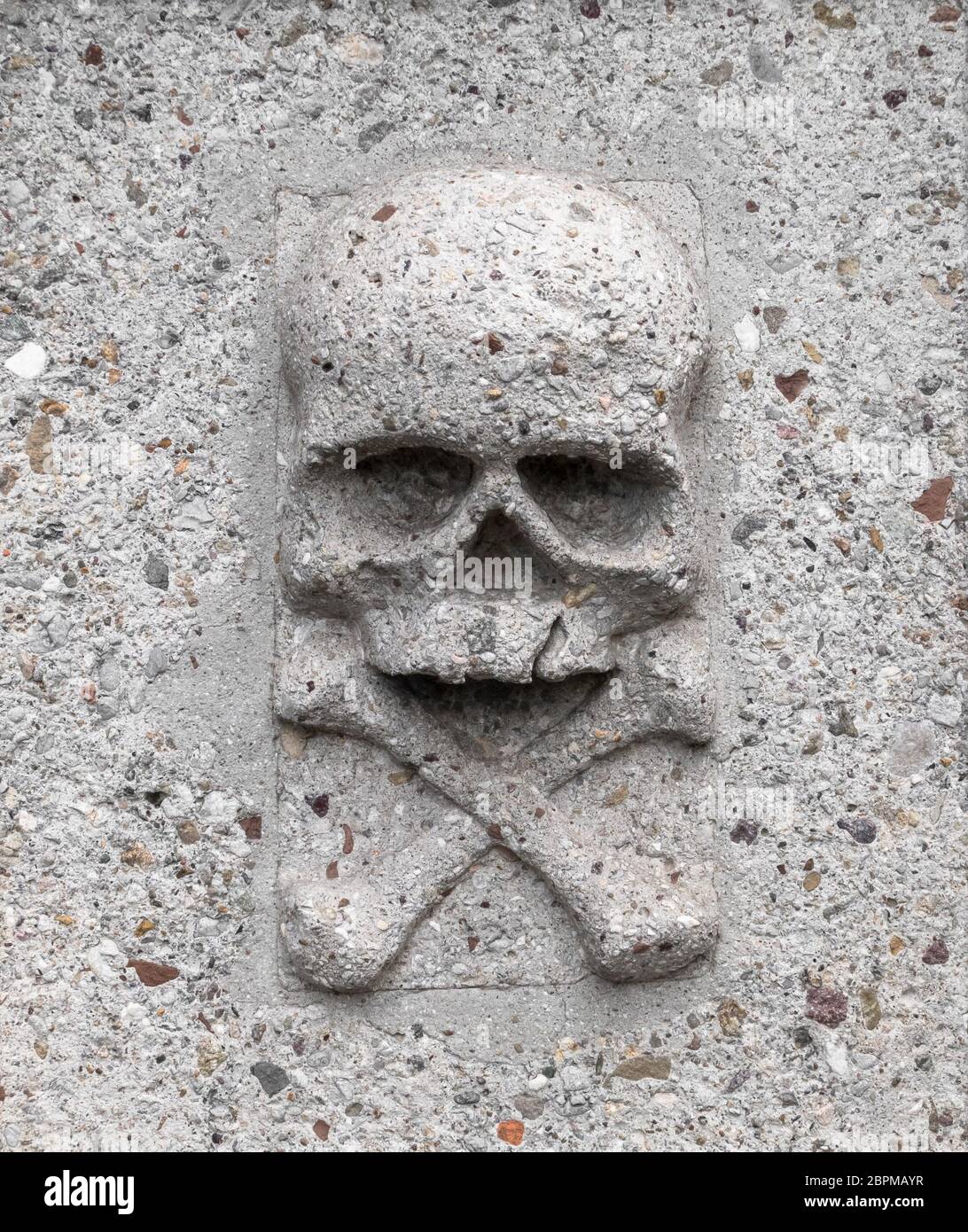 Skull with crossbones, basrelief on a gravestone in stone. Ideal for