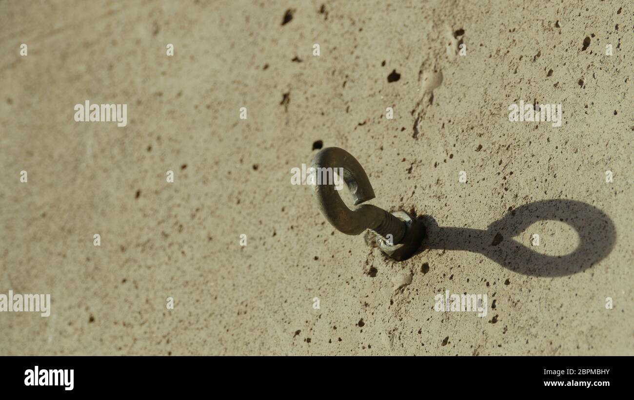 steel bolt anchor eye in the wall shadow Stock Photo Alamy