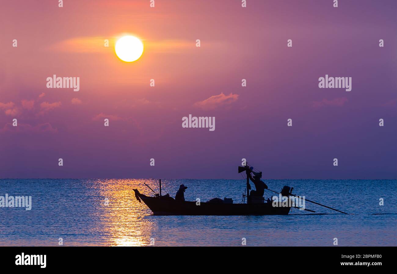 Silhouette image of Fishermen in fishing boat at sunset Stock Photo - Alamy