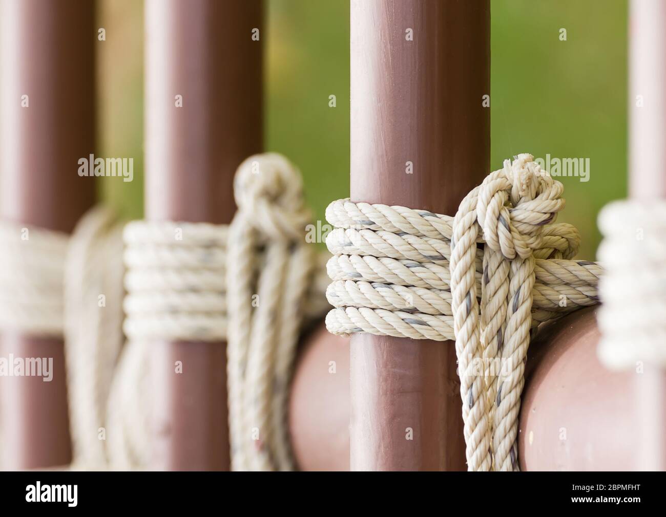Close up of rope knot around a metal fence, Rope tied knot metal pipe