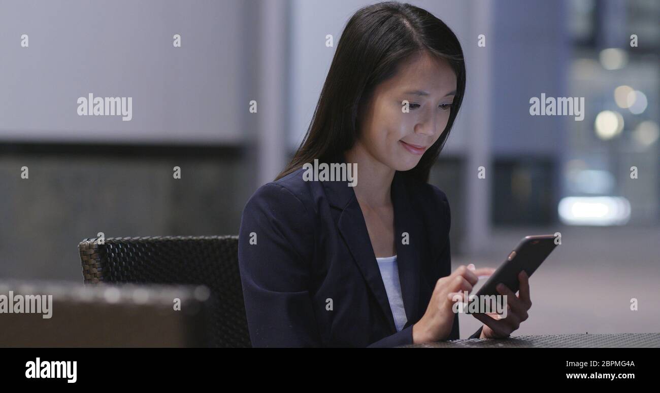 Businesswoman use of cellphone at outdoor cafe Stock Photo