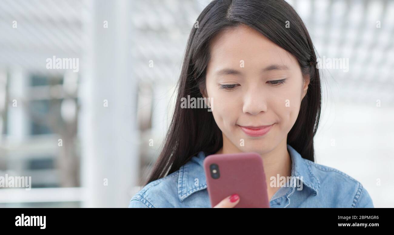 Asian woman use of mobile phone in city Stock Photo - Alamy