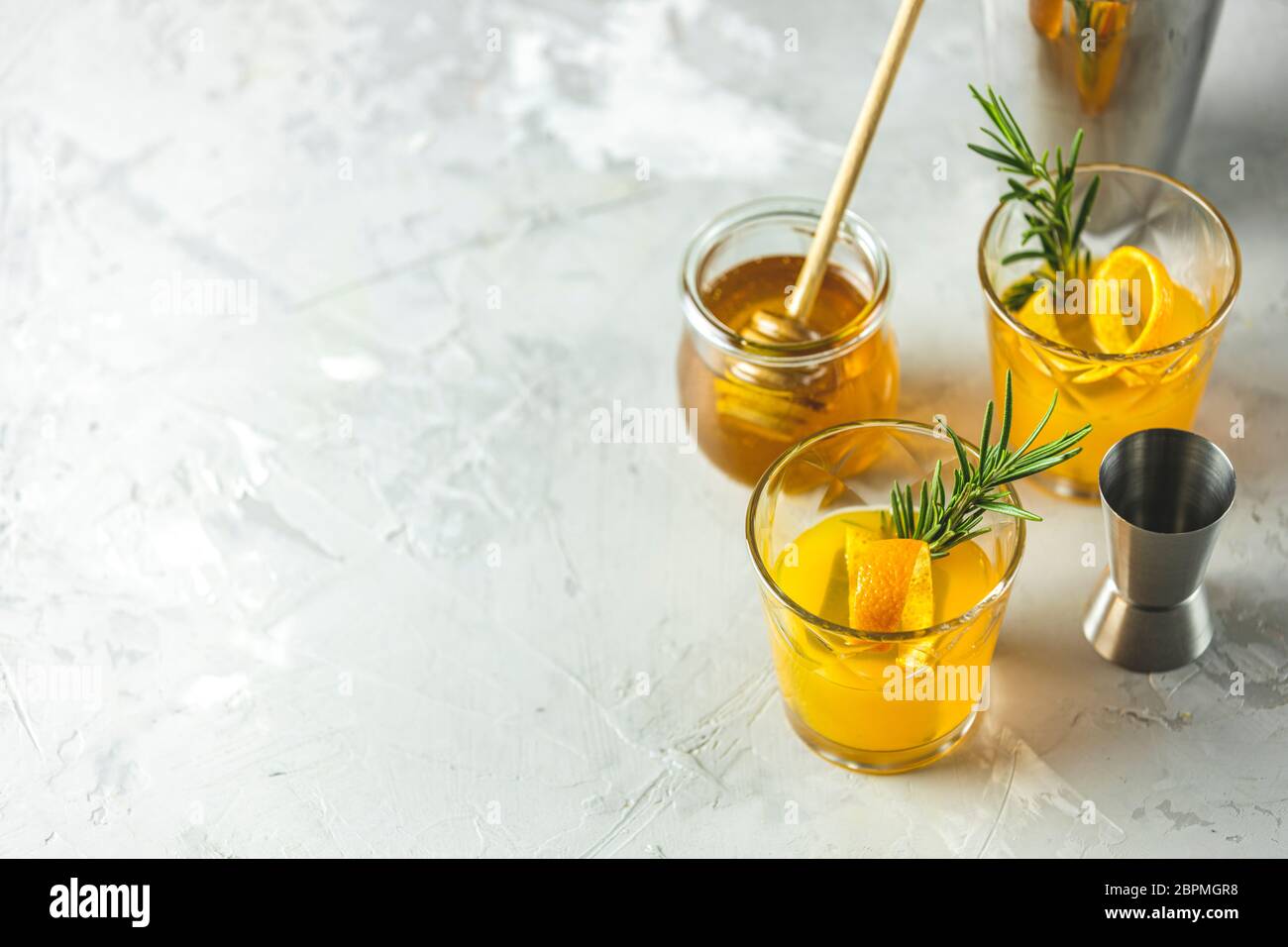 Two glasses of honey bourbon cocktail with rosemary simple syrup or homemade whiskey sour