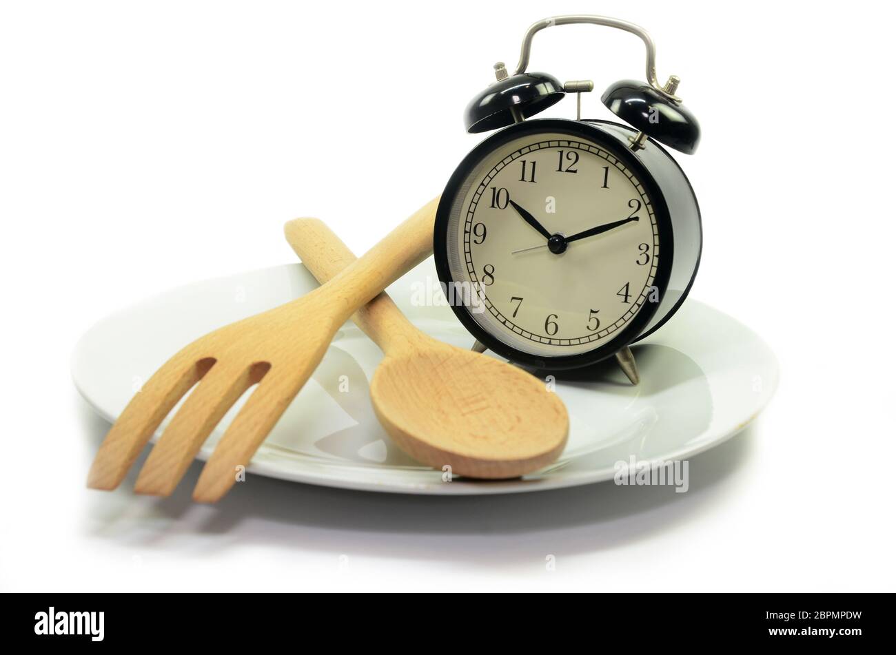 Alarm clock with fork and knife on the plate. Isolated on white. Time to  eat Stock Photo - Alamy