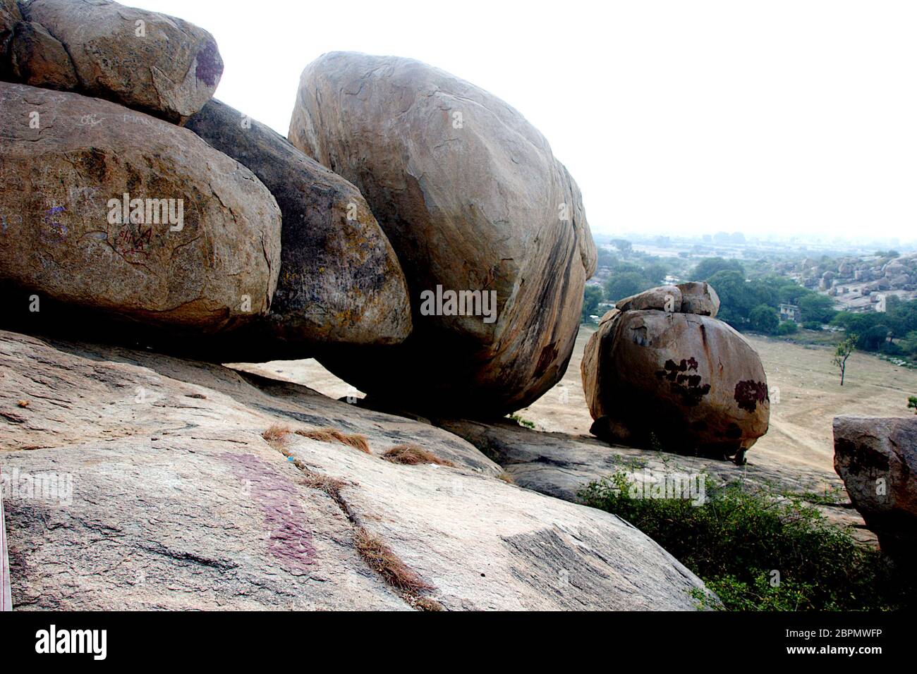 Round rock boulders resting on slope of rock surface at Jatayu Theme