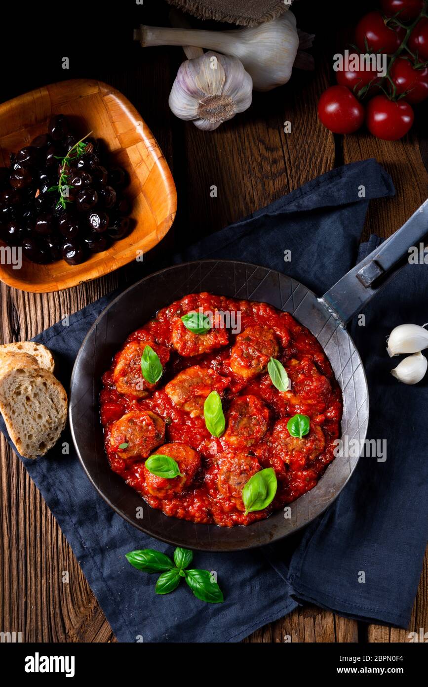 Baked mini meatballs in tomato sauce with basil Stock Photo Alamy