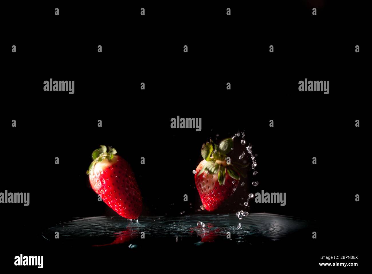 Fresh Strawberries with water splash over black background Stock Photo ...