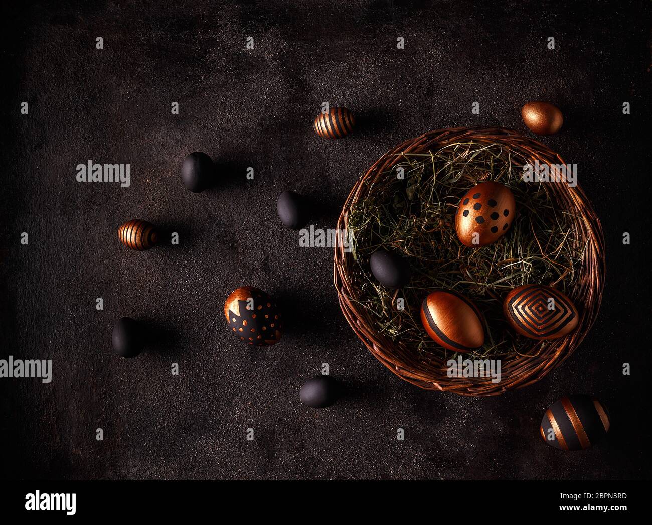 Black and gold eggs over black background. Flat lay Stock Photo
