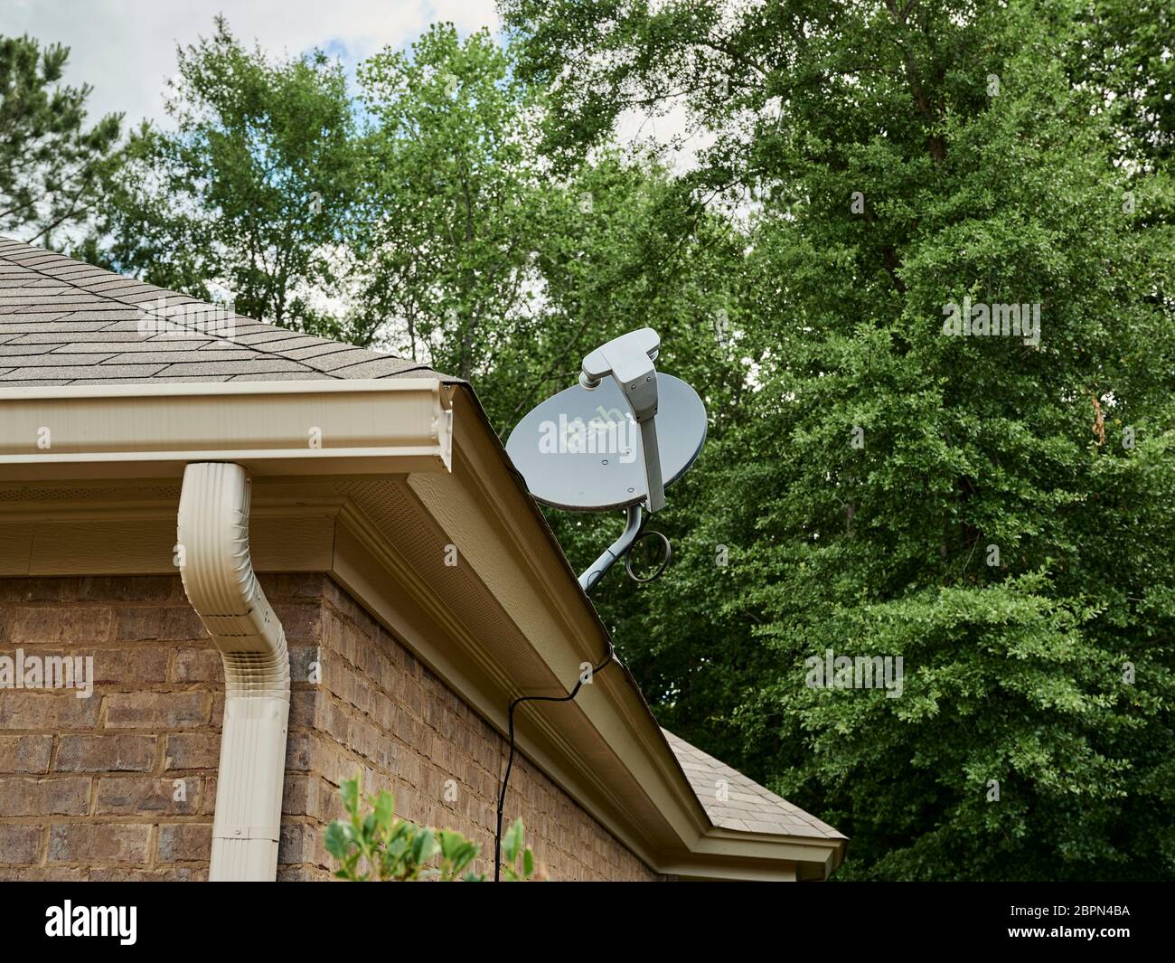 Dish TV, television, home satellite antenna  on roof of house in USA. Stock Photo