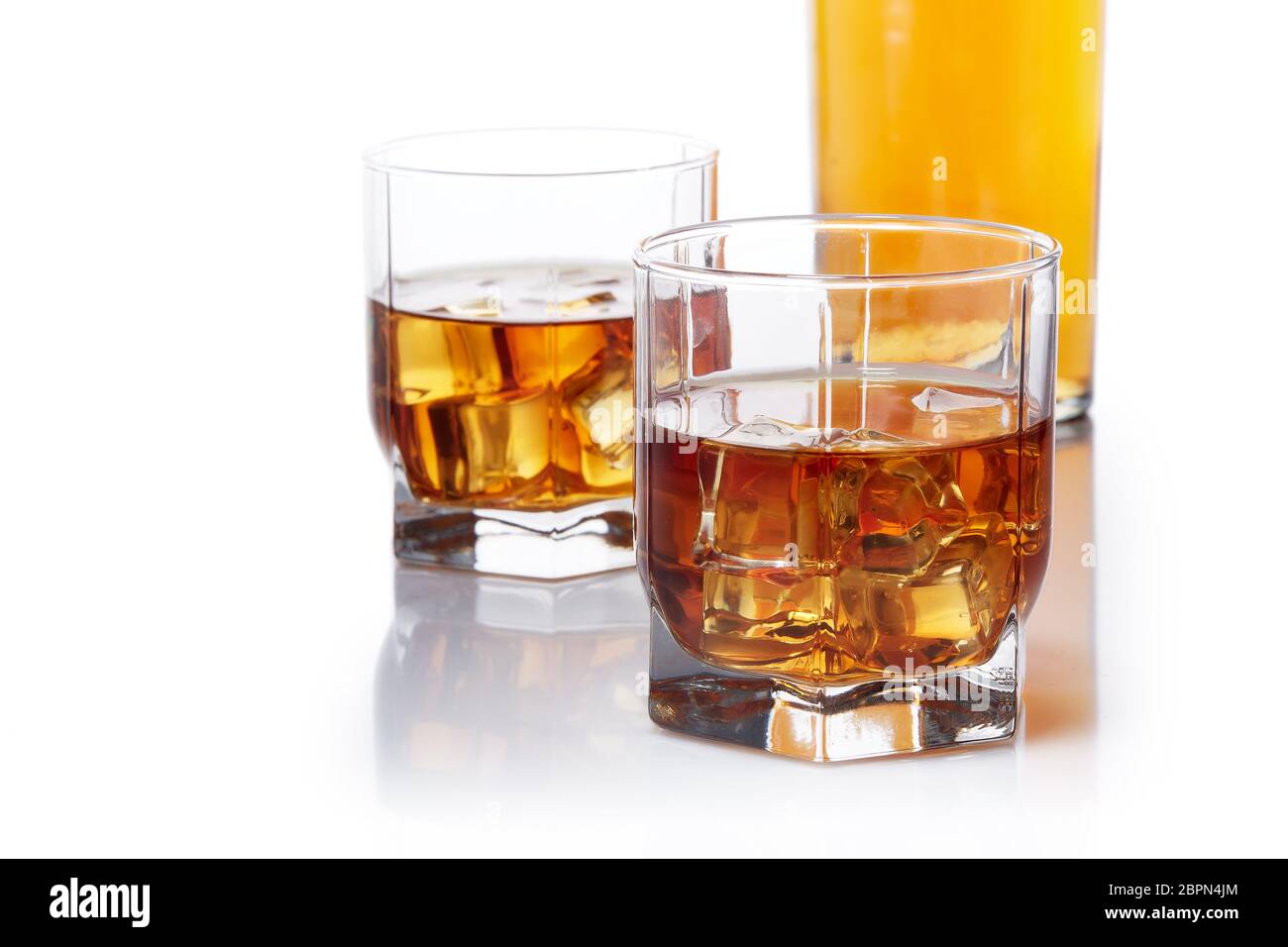 Bottle of whisky and two glasses of whisky with ices standing on a  white background with copy space. Stock Photo