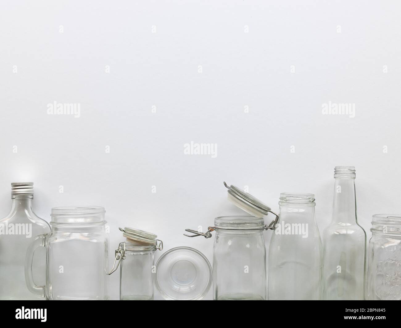 many different empty glass bottles lying on a white background Stock Photo