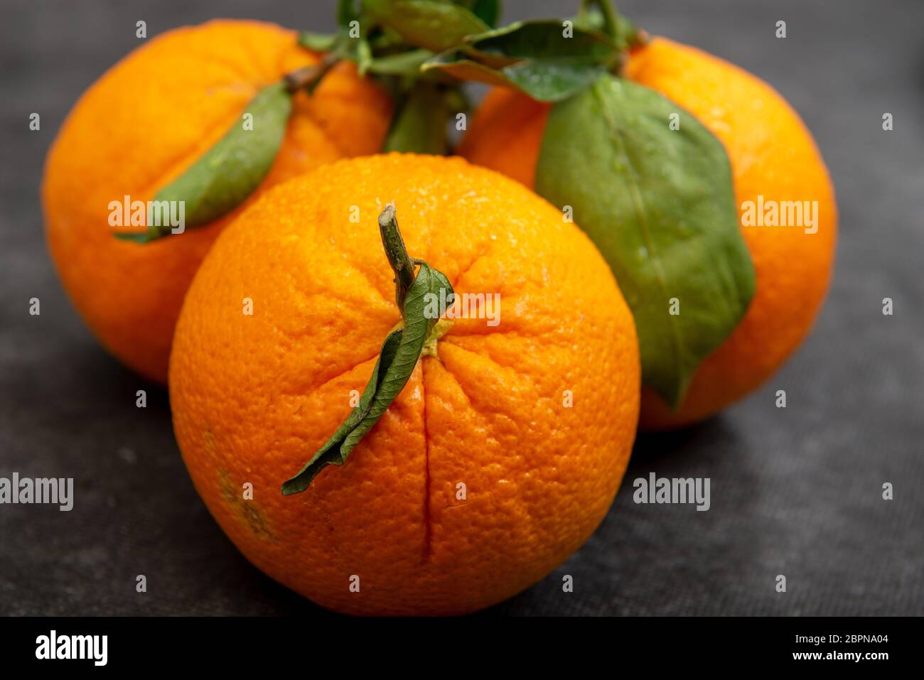 three delicious organic oranges on the black table Stock Photo