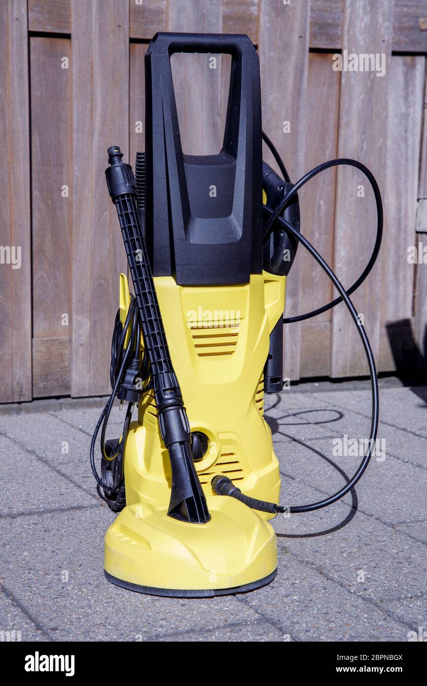Electric Pressure Washer in the Garden Cleaning Outdoor Tiles. Stock Photo