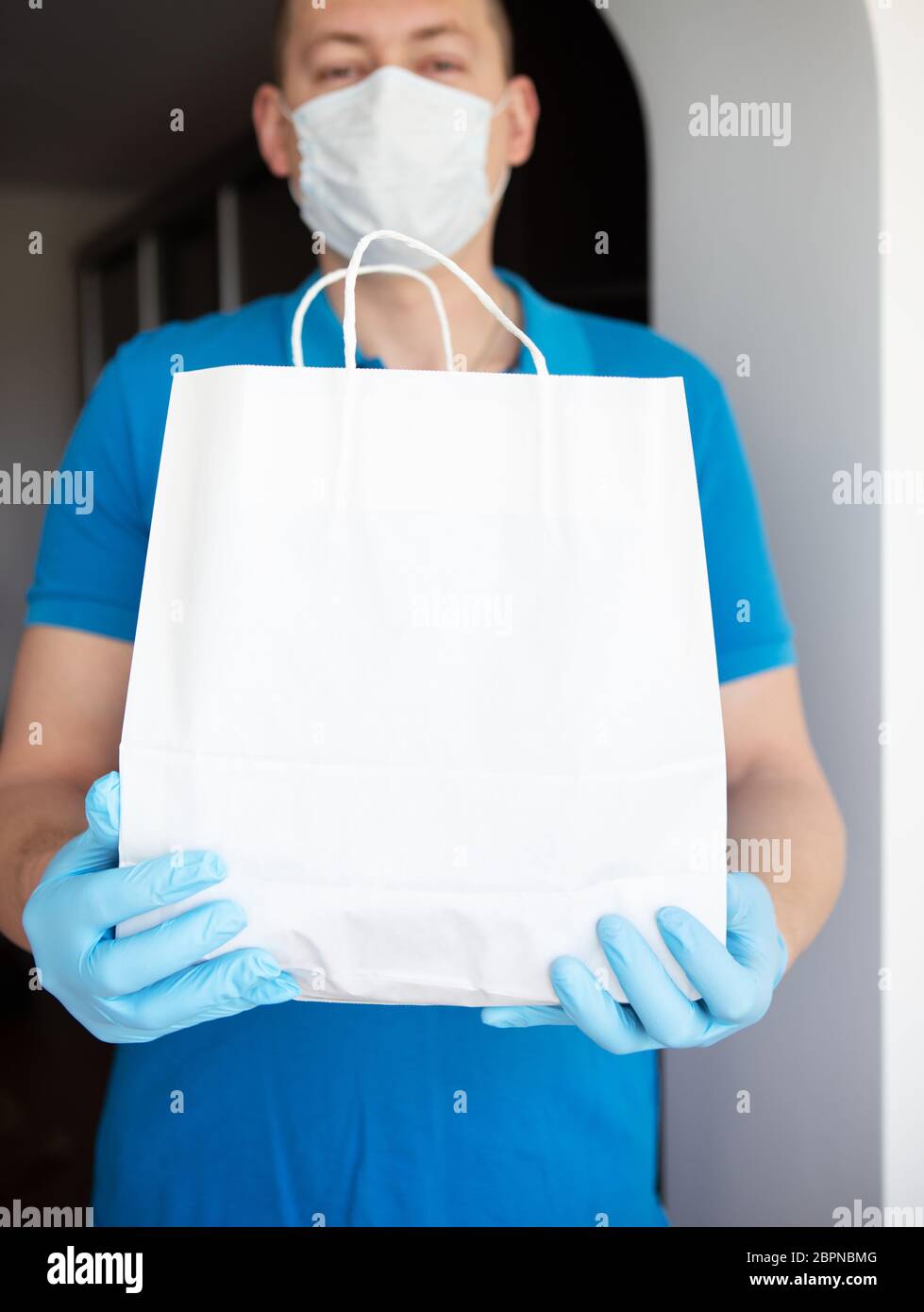Home delivery service, masked and gloved guy delivers a bag of food to ...