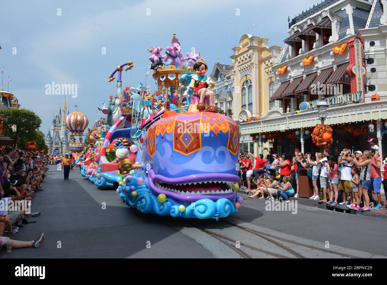 Crowds watch the Festival of Fantasy Parade at the Magic Kingdom park