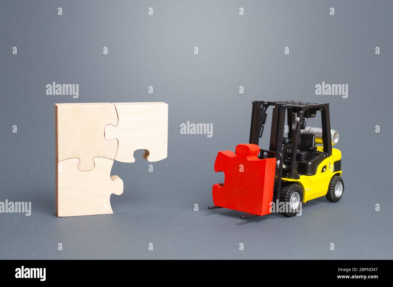 A forklift truck picks up the missing puzzle piece. Organization and systematization, step by step instructions. Procedure, key condition. Business pl Stock Photo