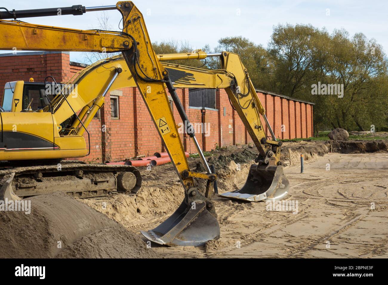 two yellow excavators parked at construction site Stock Photo - Alamy