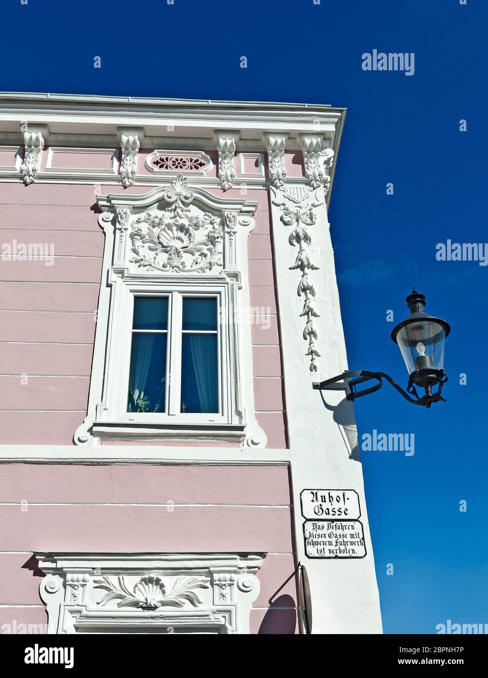 white baroque house front with ornaments, arabesques and window framework and a lantern, Weitra, Austria Stock Photo