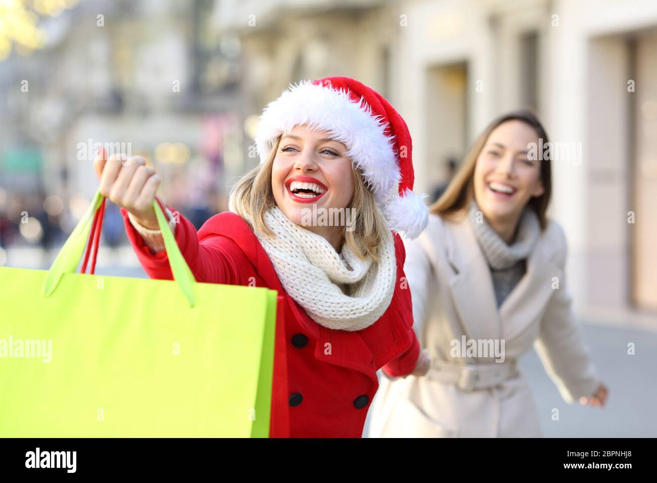 Shoppers shopping and showing bags in christmas outdoor on the street Stock Photo